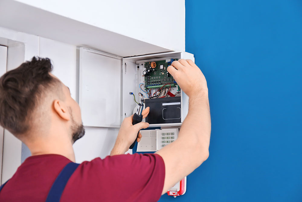 Technician installing a security control panel
